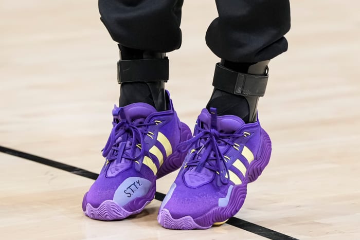 Atlanta Hawks guard Trae Young's purple and gold adidas sneakers.